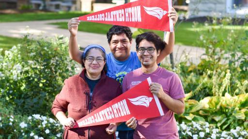 first-gen family posing with NCC flags